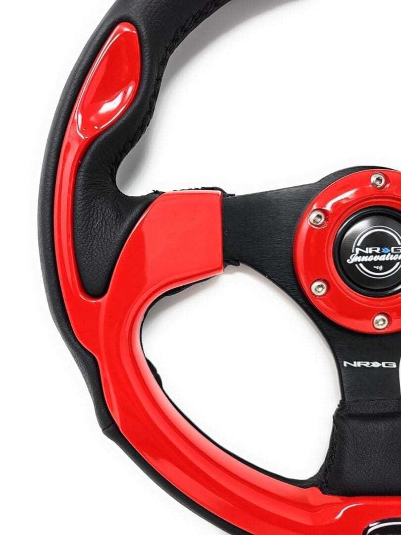Close-up of a red and black racing steering wheel with ergonomic grips.