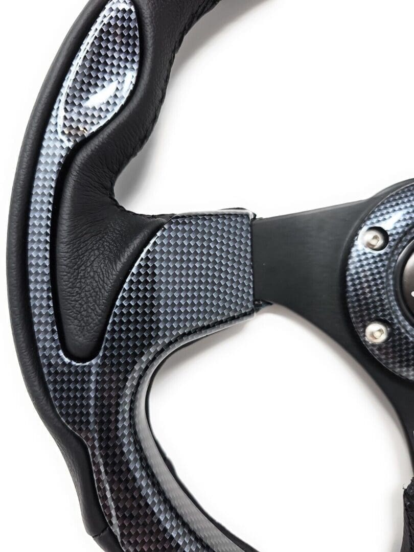 Close-up of a carbon fiber steering wheel with ergonomic grips.