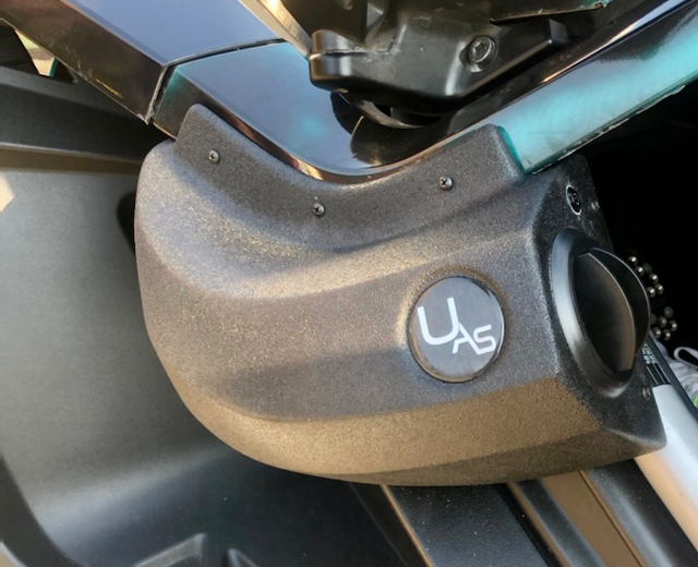 Close-up of a UAG-branded gear shift lever in a vehicle.