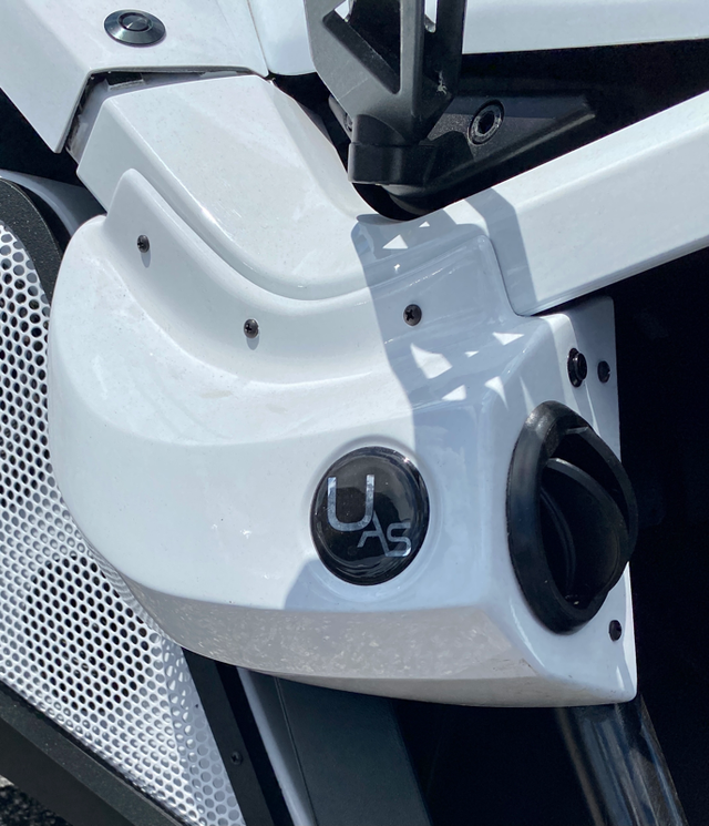 Close-up of a white motorcycle with a UAS badge.