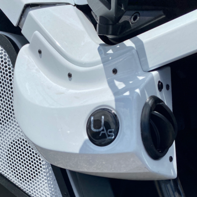 Close-up of a white motorbike with a gas cap and logo.