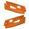 Two orange plastic car bumper parts with cutouts.