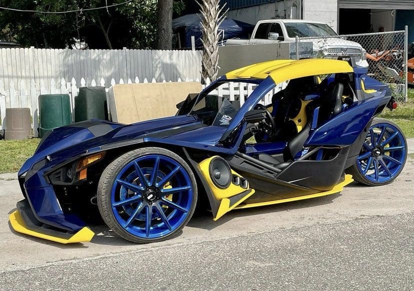A customized blue and yellow sports car with unique wheels and a sleek design.