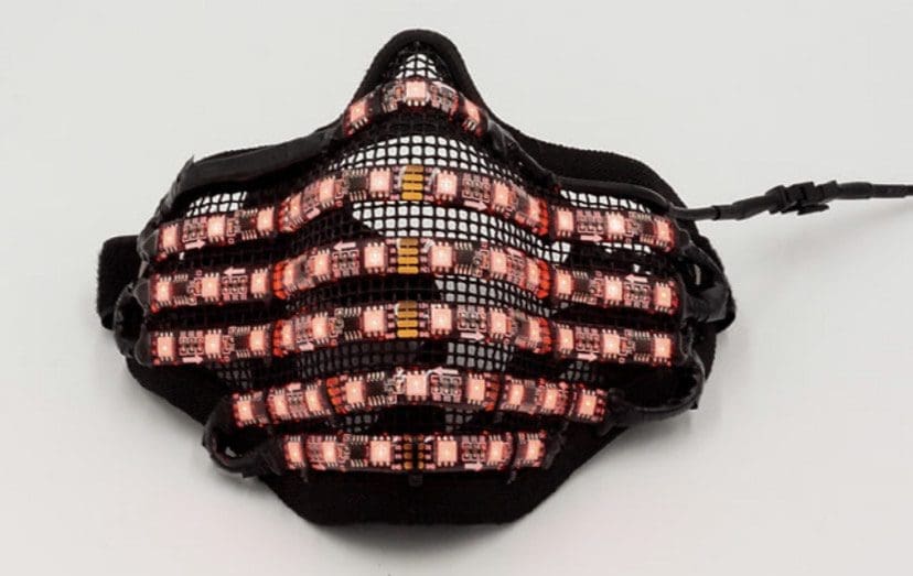 A black LED mask with colorful lights displaying patterns.