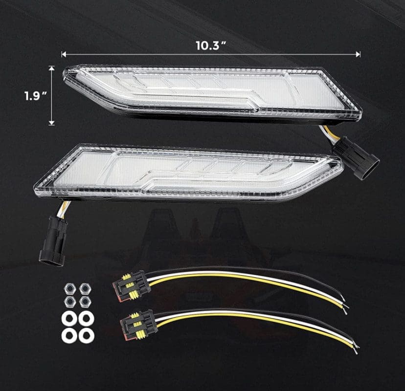Pair of clear LED car lights with wiring and mounting hardware on black background.