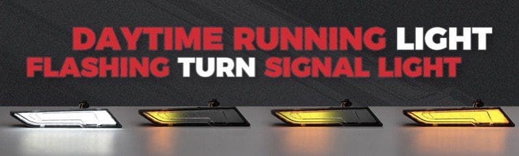 Close-up of car turn signal lights illuminated on a dark surface.