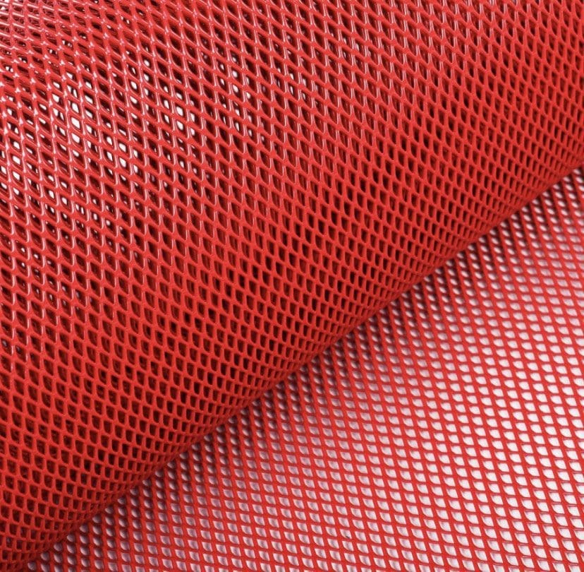 Close-up of red mesh fabric with a honeycomb pattern.