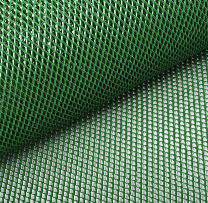 Green mesh netting material rolled out on a surface.