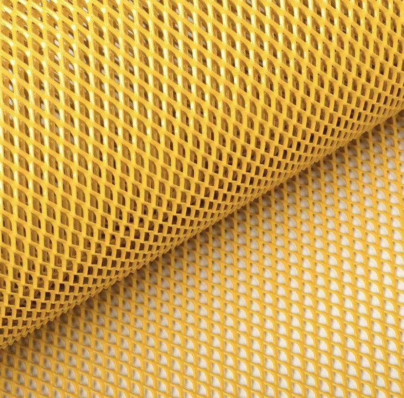 Close-up of a yellow plastic mesh roll with diamond-shaped holes.