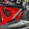 Close-up of a red and black motorcycle part with a sleek design.