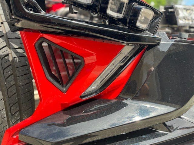 Close-up of a red and black motorcycle part with a sleek design.