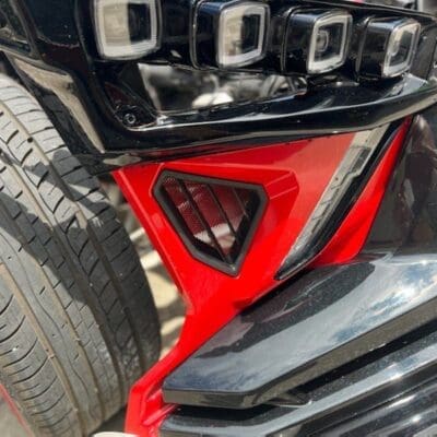 Black and red car bumper with a grill