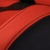 Close-up of red and black leather upholstery with detailed stitching.