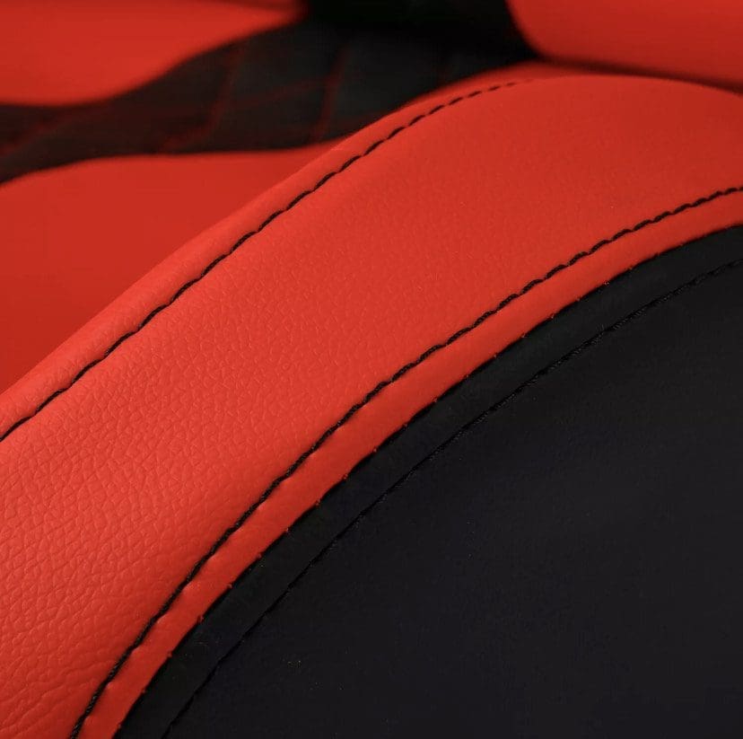 Close-up of red and black leather upholstery with detailed stitching.