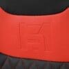 Close-up of red and black leather with embossed logo and red stitching.