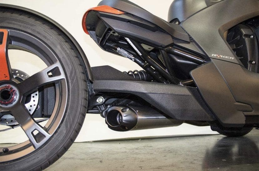 Close-up of a motorcycle's rear wheel and exhaust system.