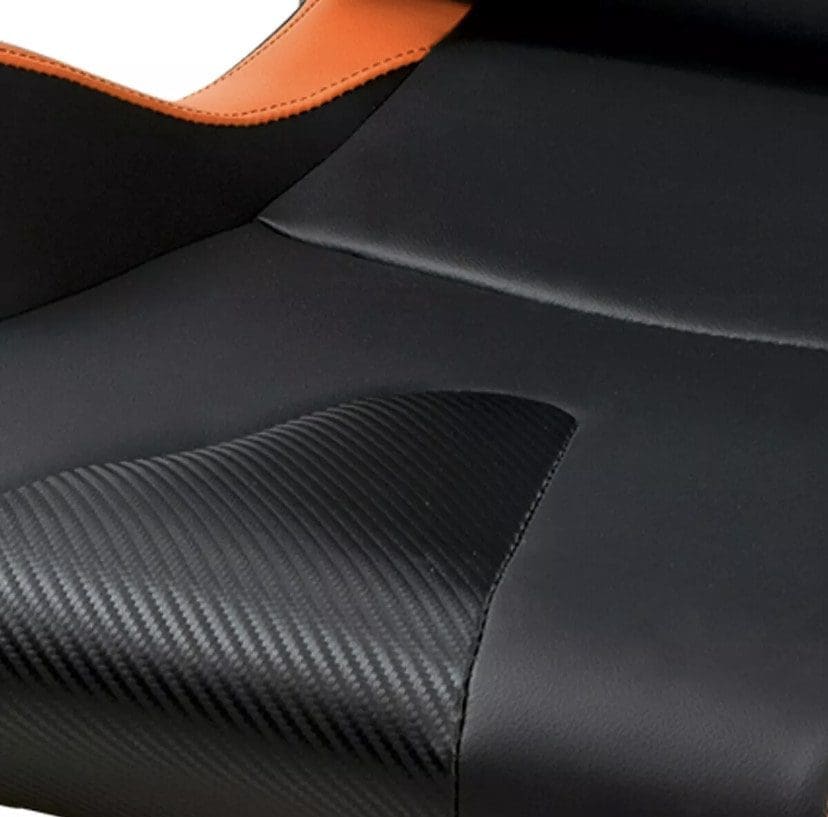 Close-up of a black textured car seat with orange accent.