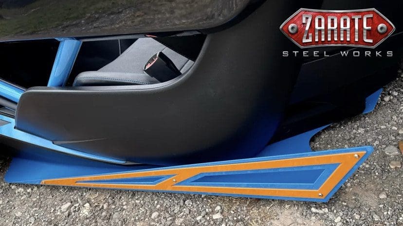Close-up of a car door sill with blue and orange accents and a partial view of the interior.