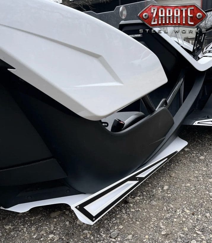 Close-up of a white and black motorcycle body part with detailed design.