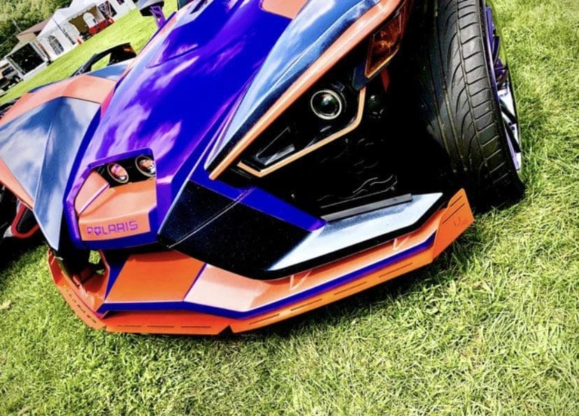 Close-up of a sporty Polaris vehicle with a vibrant purple and orange color scheme.