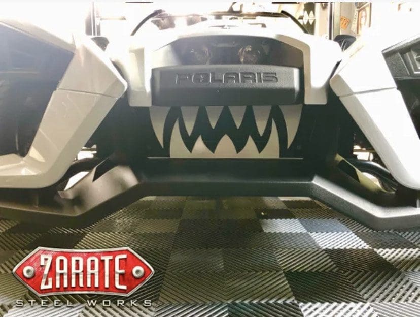 Close-up of a Polaris vehicle with a custom Zarate Steel Works logo and aggressive teeth design.