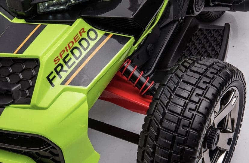 Close-up of a green off-road vehicle's suspension and tire.
