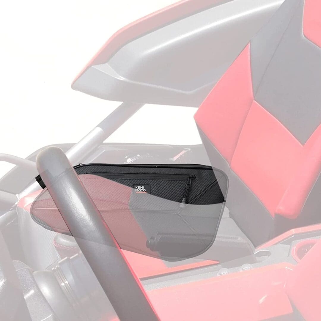 Close-up of a red and black seat in a vehicle with a steering wheel visible.