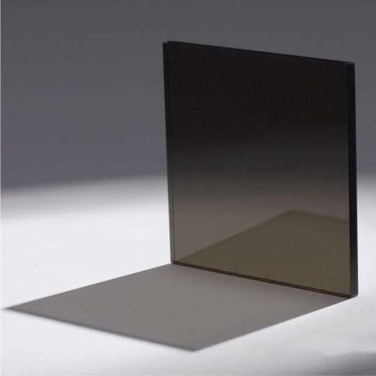 Square glass panel casting a shadow on a flat surface.