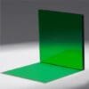 A green glass pane casting a vivid green shadow on a white surface.