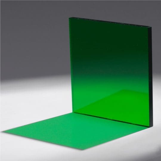 A green glass pane casting a vivid green shadow on a white surface.