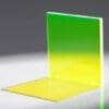 A glowing translucent panel with a gradient from green to yellow, casting a colorful shadow.