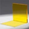 A transparent yellow acrylic sheet standing and lying flat on a gray surface.