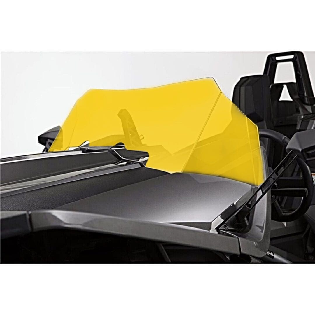 Close-up of a sleek black racing car with a bright yellow cockpit cover.