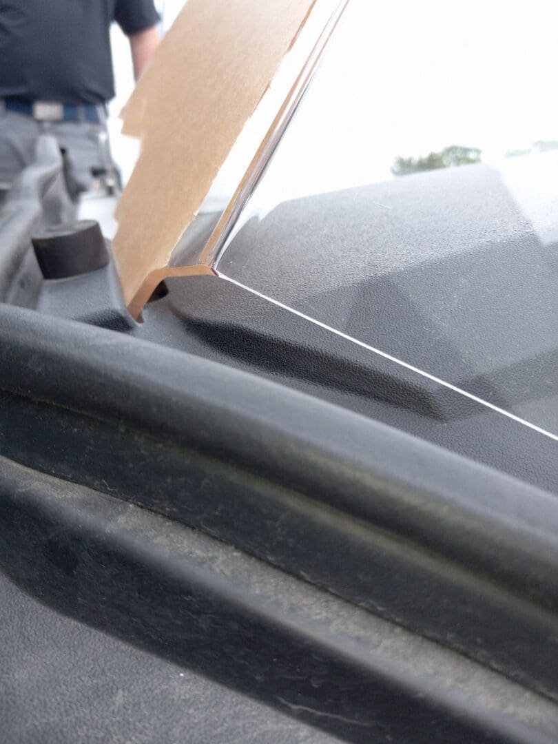Close-up of a windshield with a visible crack and wiper blade.