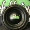 Close-up of a black subwoofer speaker with a green crown logo.
