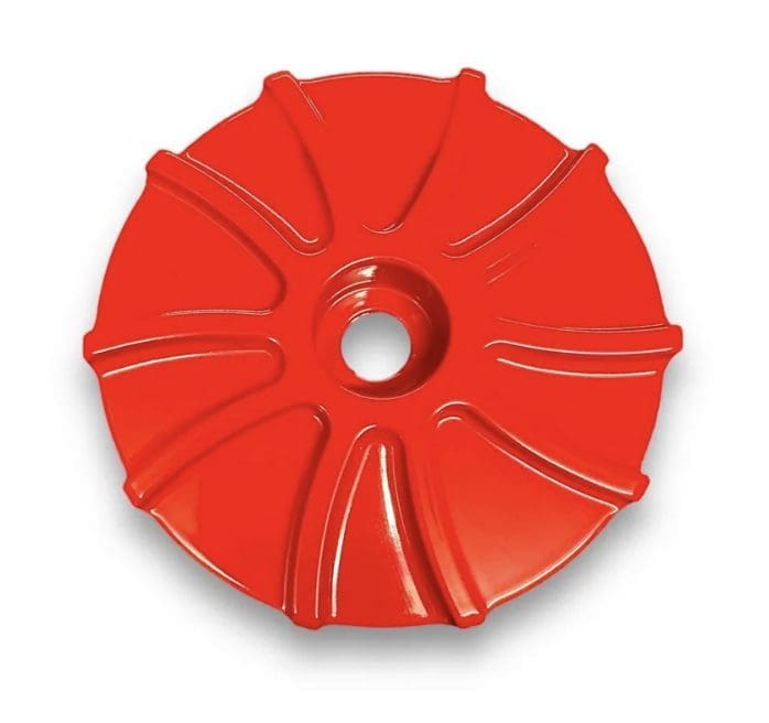 Red circular object with radial grooves and central hole.