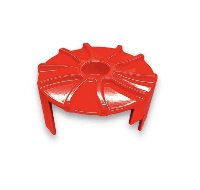 Red plastic circular object with multiple grooves and legs.