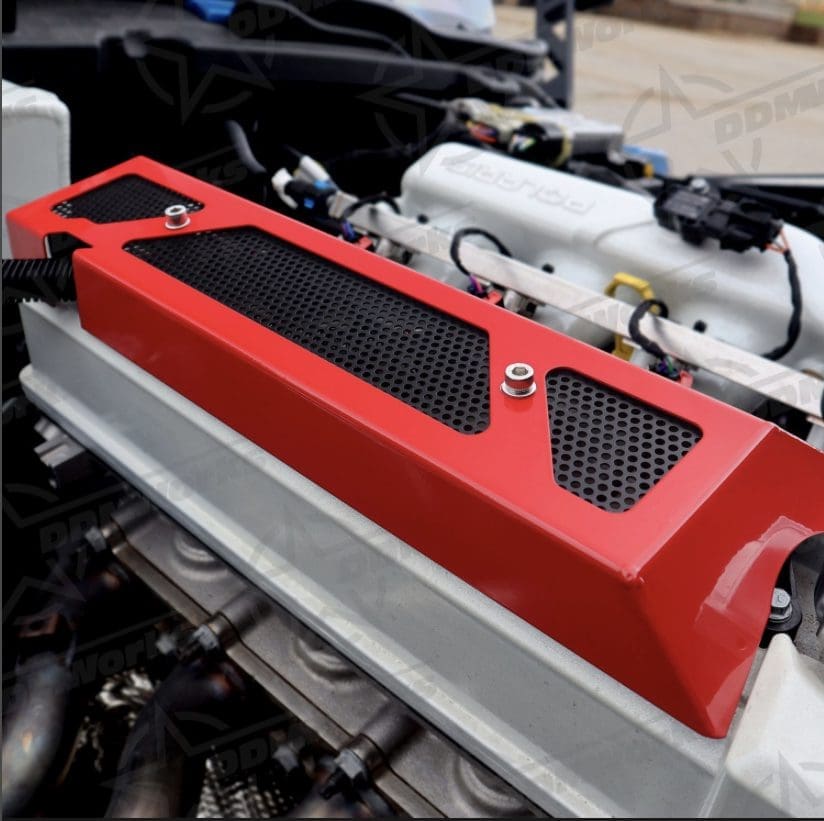 Close-up of a red engine cover with black vents.