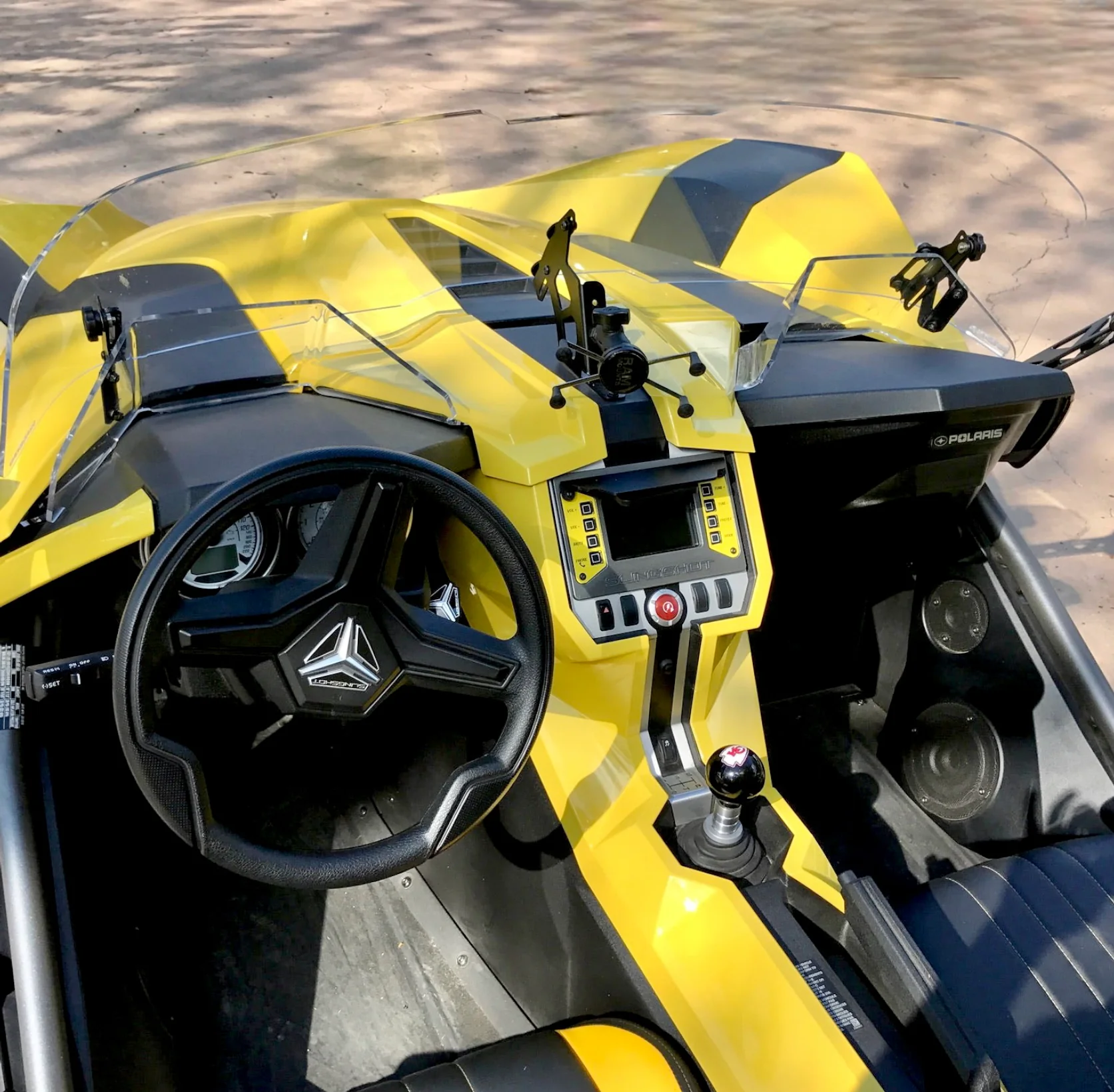 Close-up of a yellow and black sports car interior with a steering wheel and modern dashboard.
