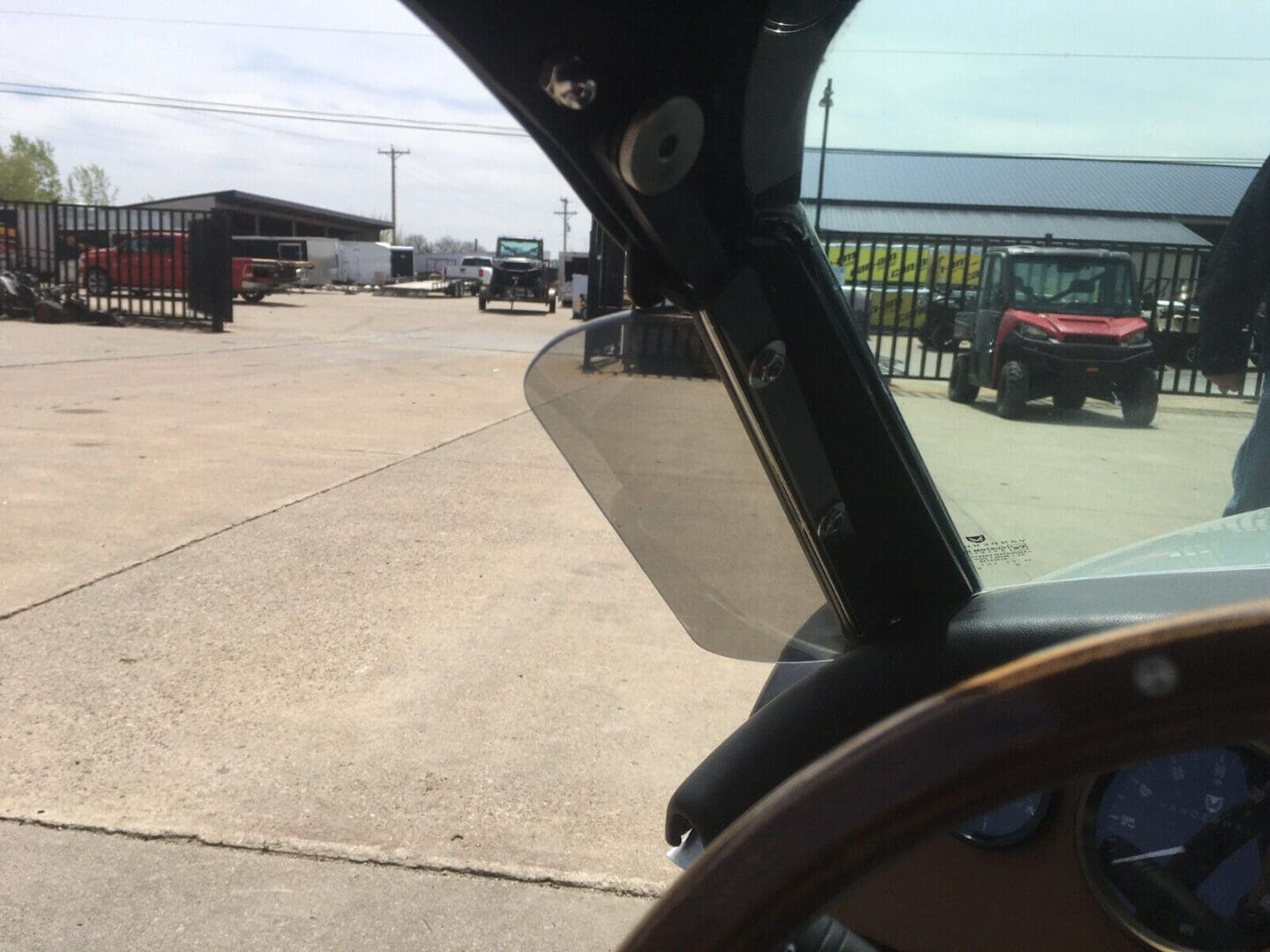 View from inside a vehicle showing the driver's side window and side mirror.
