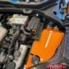 Close-up of a car engine bay with an orange component.
