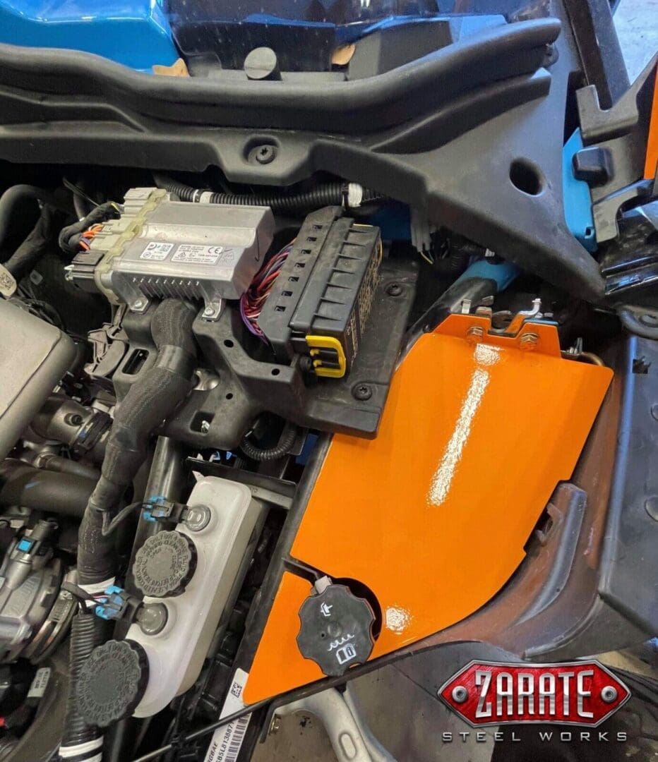 Close-up of a car engine bay with an orange component.