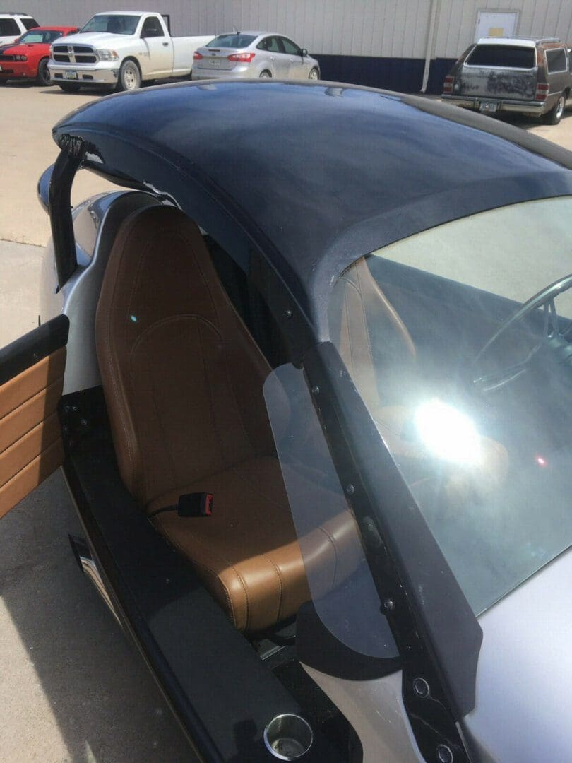 Close-up of a car's interior with a leather seat and window frame.