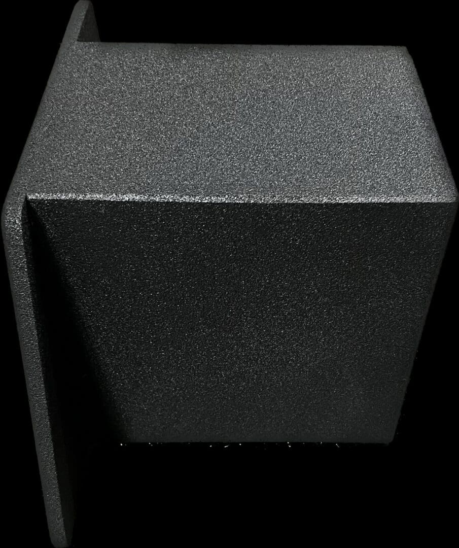 Close-up of a textured black cube with sharp edges.