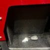 Car key and keychain resting in a vehicle's storage compartment.