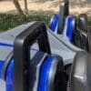 Close-up of blue and black amusement park ride seats with safety bars.