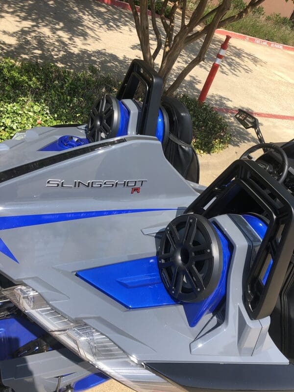 Close-up of a blue and silver vehicle with a mounted speaker system.
