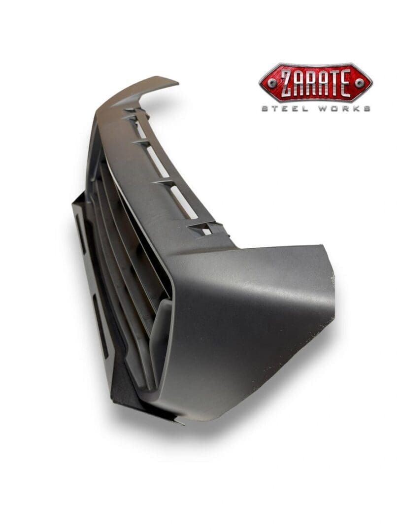 Black front bumper for a vehicle with grille and fog light openings.