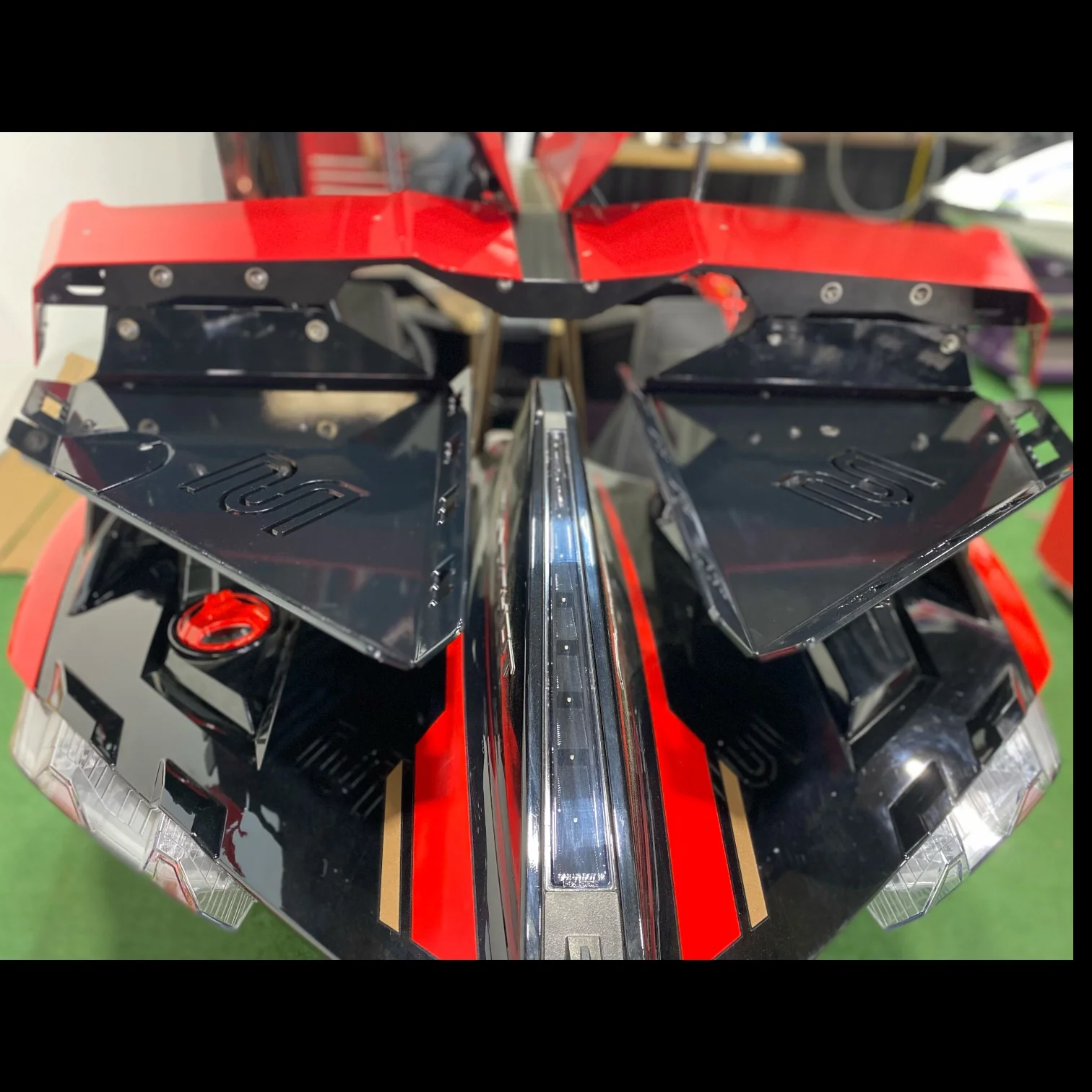 Close-up of a red and black mechanical part with metal and plastic components.