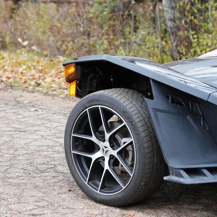 Close-up of a modern car's rear wheel and part of the body.